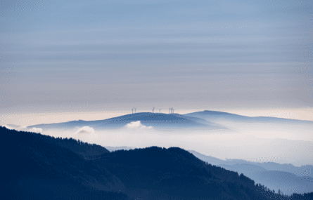 Hazy hills with wind turbines in the distance.