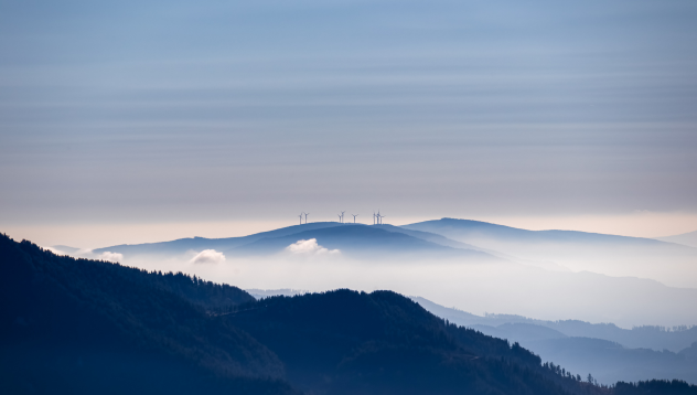 Hazy hills with wind turbines in the distance.