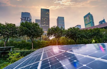 City skyline at sunset with solar panels in the foreground.